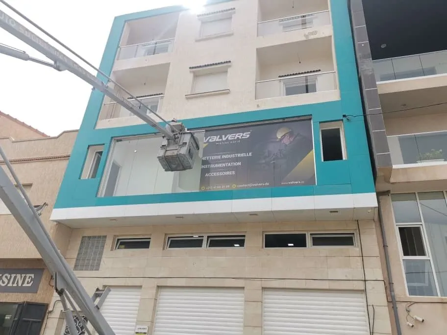 Valvers storefront sign being installed on a building facade